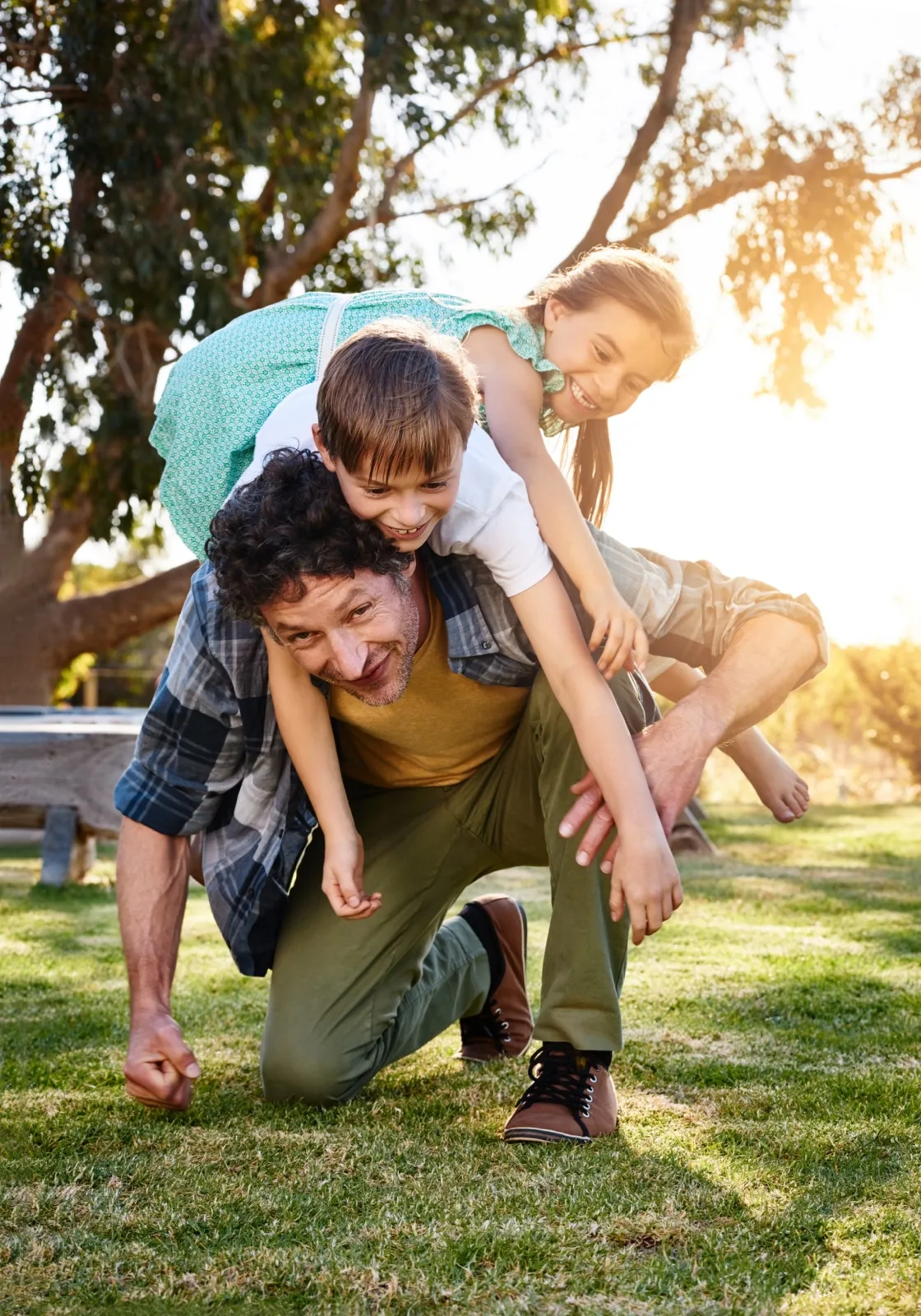 A father playing outdoors with his two children